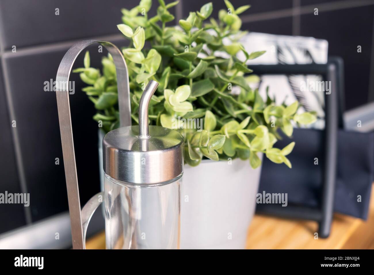 Topf mit grüner Pflanze auf Küchenarbeitsplagefläche. Nahaufnahme Stockfoto