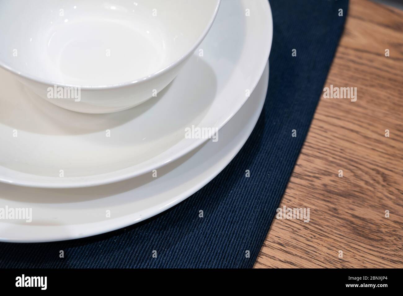 Leere weiße Teller auf Holztisch. Nahaufnahme Stockfoto