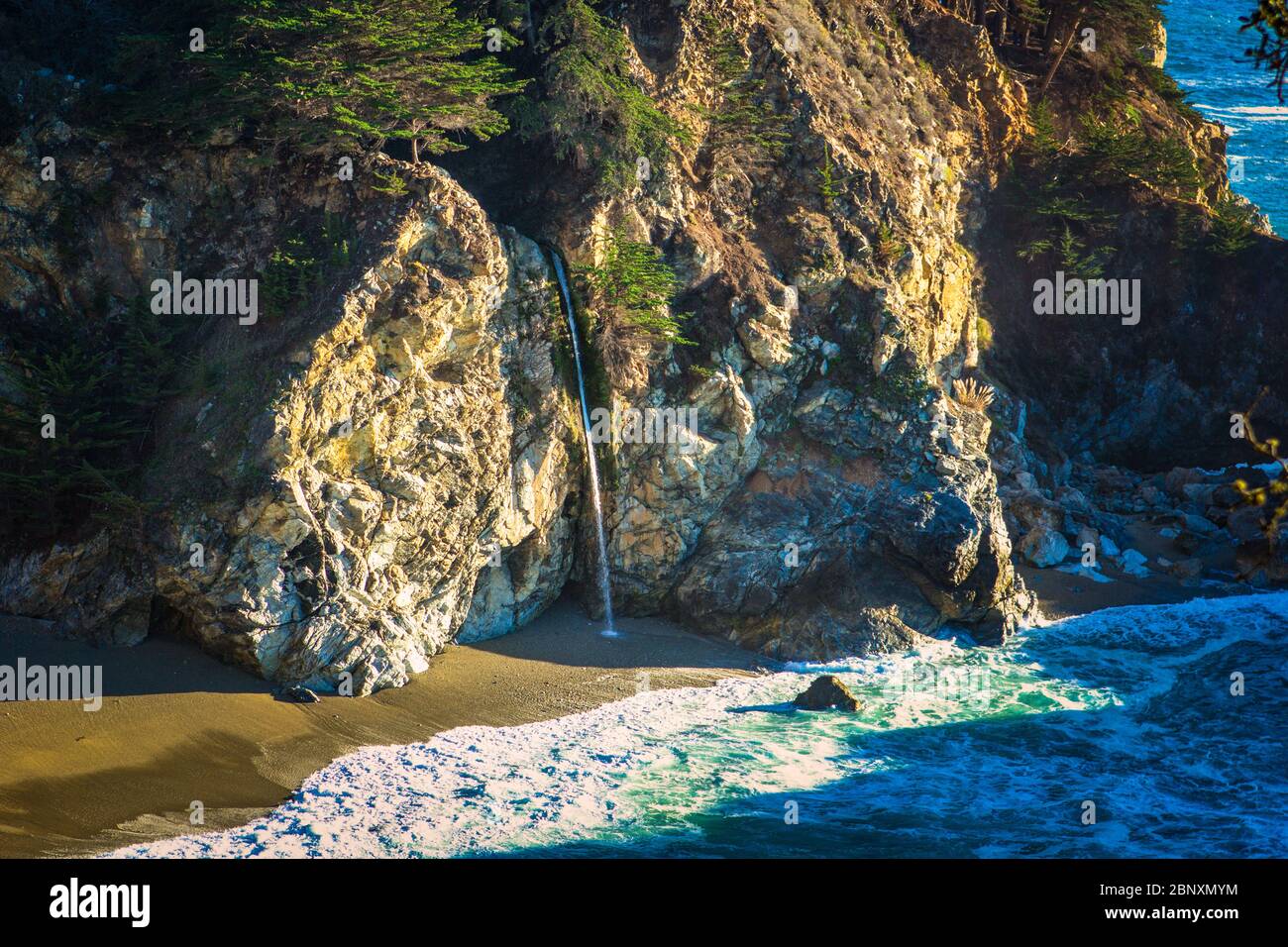 Ein Wasserfall, der auf einen Strand in Big Sur, Kalifornien, fließt Stockfoto