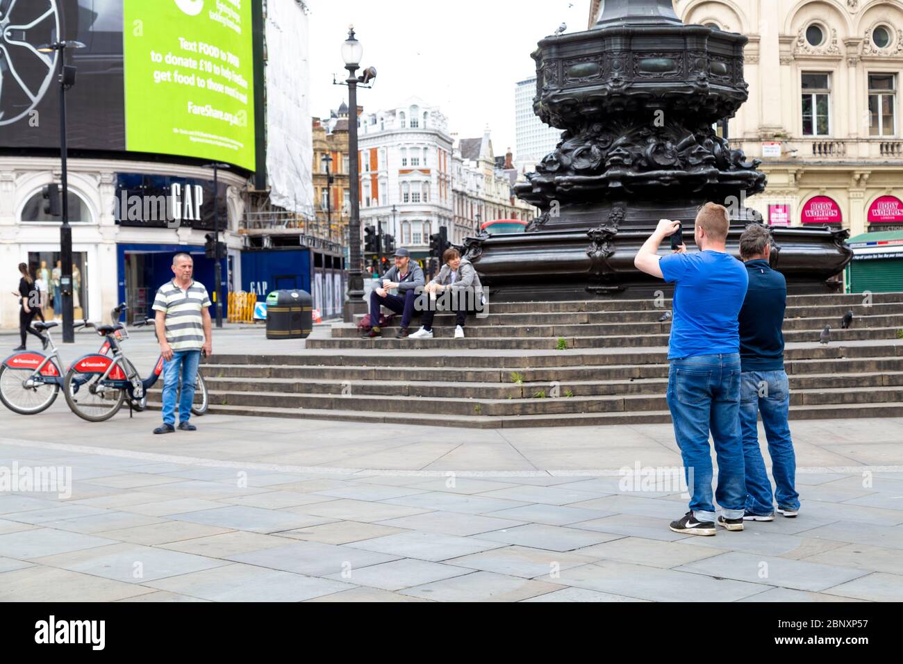 16 Mai 2020 London, UK - Touristen im Piccadilly Circus während der Sperrung der Coronavirus-Pandemie fotografieren Stockfoto