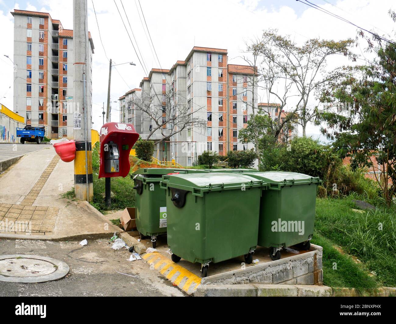 Medellin, Kolumbien, Oktober 15 2019: Container für die Rücksammlung von Festabfällen auf einem Hügel in Medellin mit Gebäuden im Hintergrund Stockfoto