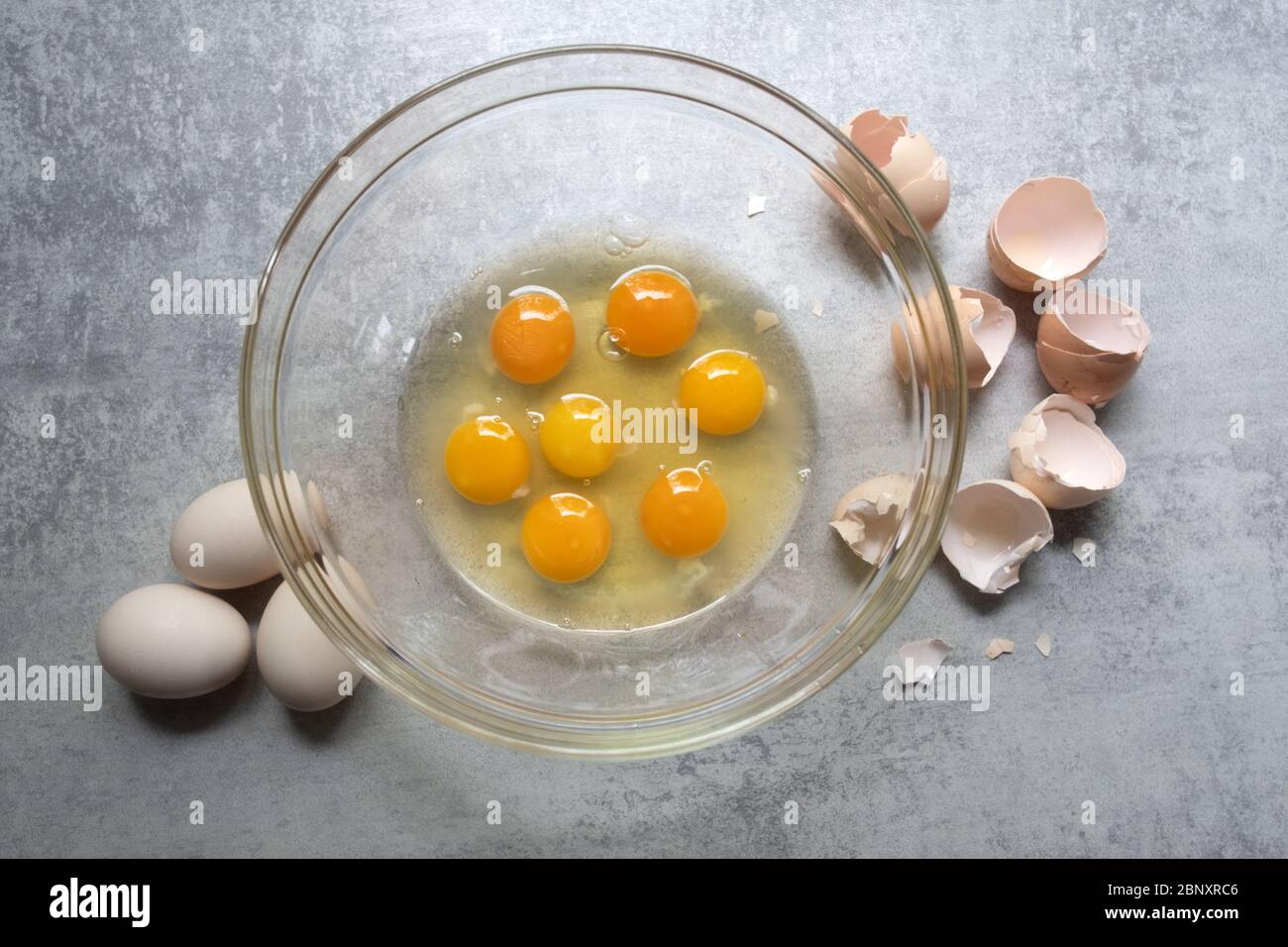 Rohen Eiern in Glasschüssel am Küchentisch. Vorbereitung der Omelette Stockfoto