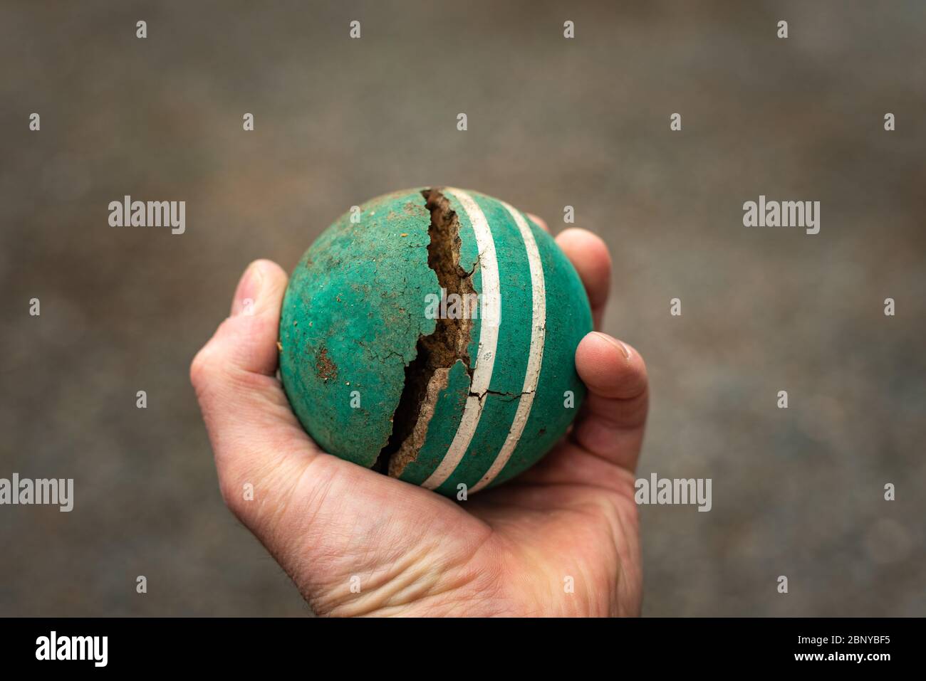 Kaukasischer Rüde mit einem gebrochenen grünen Vintage Krocketball Stockfoto