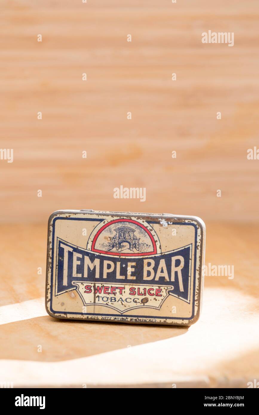 Ein Stillleben Studiobild auf einem hellen Holzhintergrund einer antiken Tabakdose mit dem Temple Bar Sweet Slice Logo darauf gemalt Stockfoto