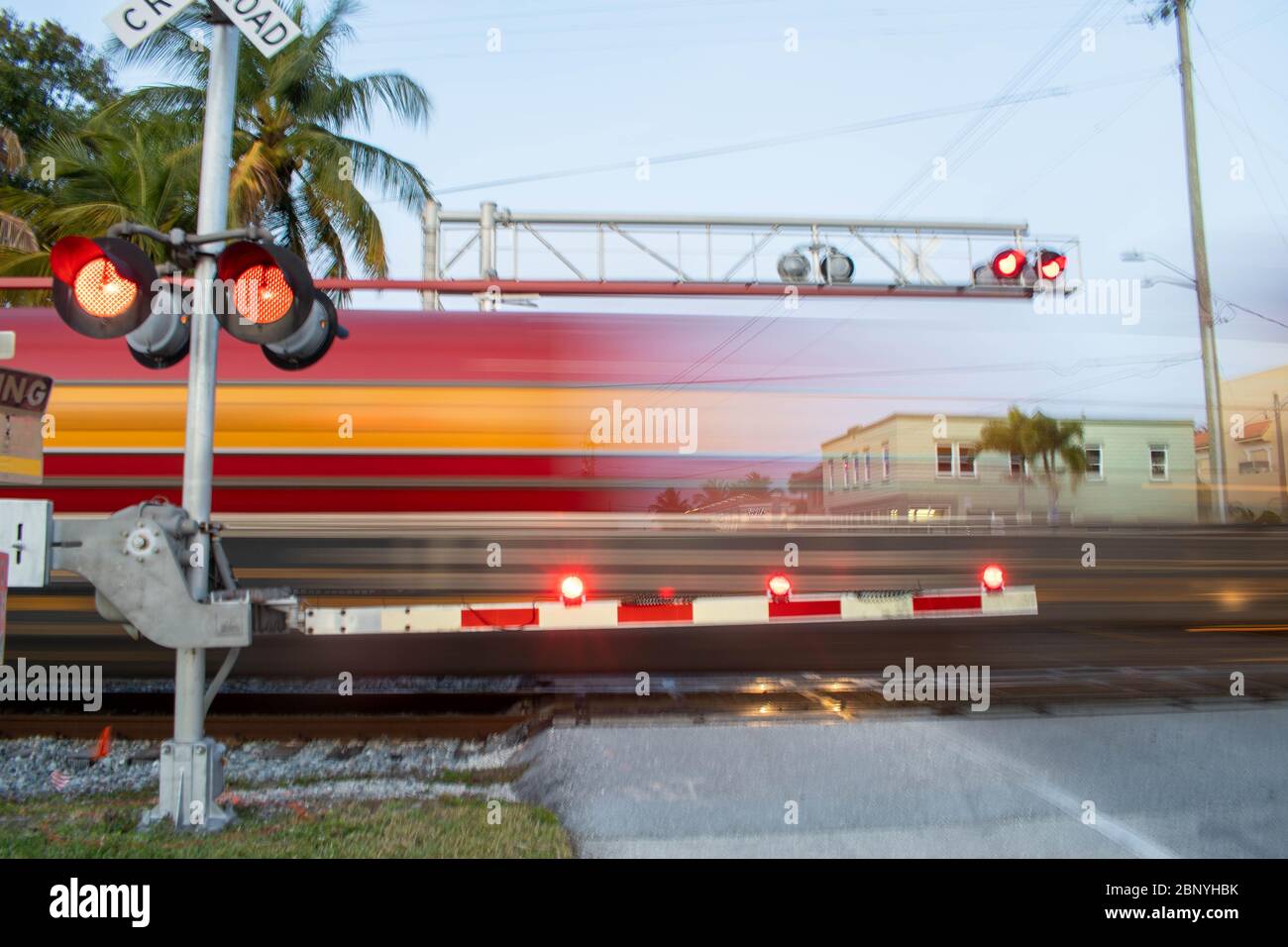 Der Zug brüllt durch und Kreuzung, während Autofahrer mit blinkenden roten Lichtern und Bars in Stuart Florida gewarnt werden Stockfoto