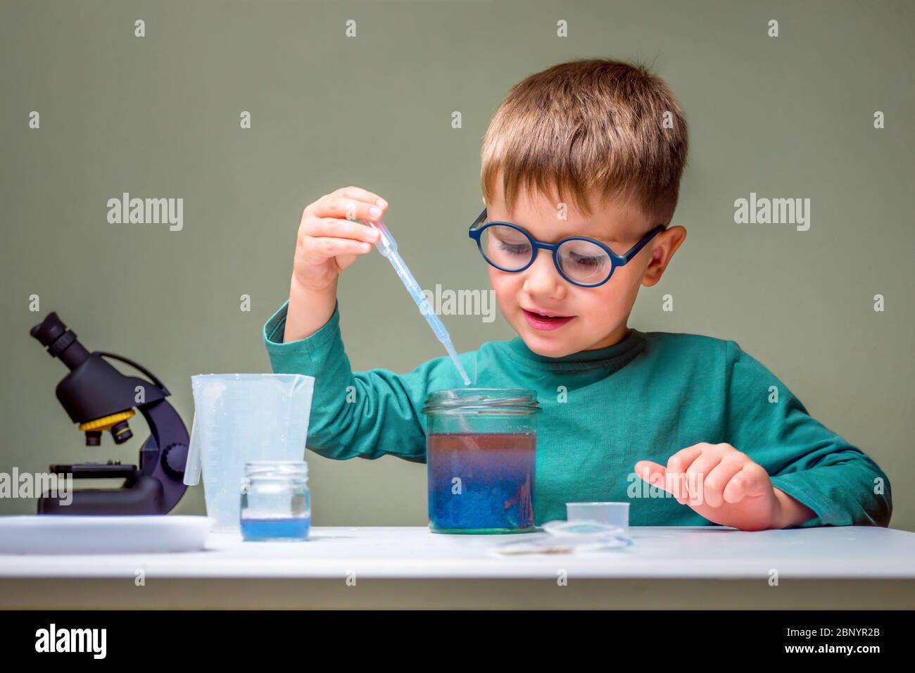 Kleiner Junge studiert Chemie. Testen von Röhrchen mit Flüssigkeit für die Forschung. Lernen Sie für die Zukunft. Biologie. Vorschulalter zu Hause. Kleines Genie Kind Stockfoto