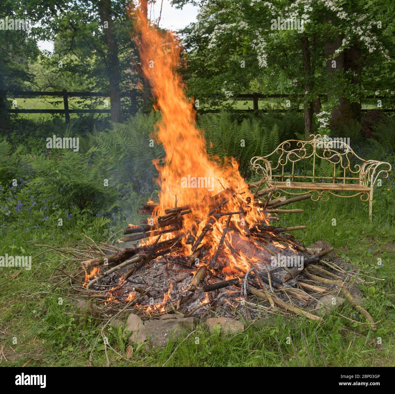 Springen Flammen aus einem Lagerfeuer in einem Feuer Grubenin einem Land Cottage Garden in Rural Devon, England, Großbritannien Stockfoto