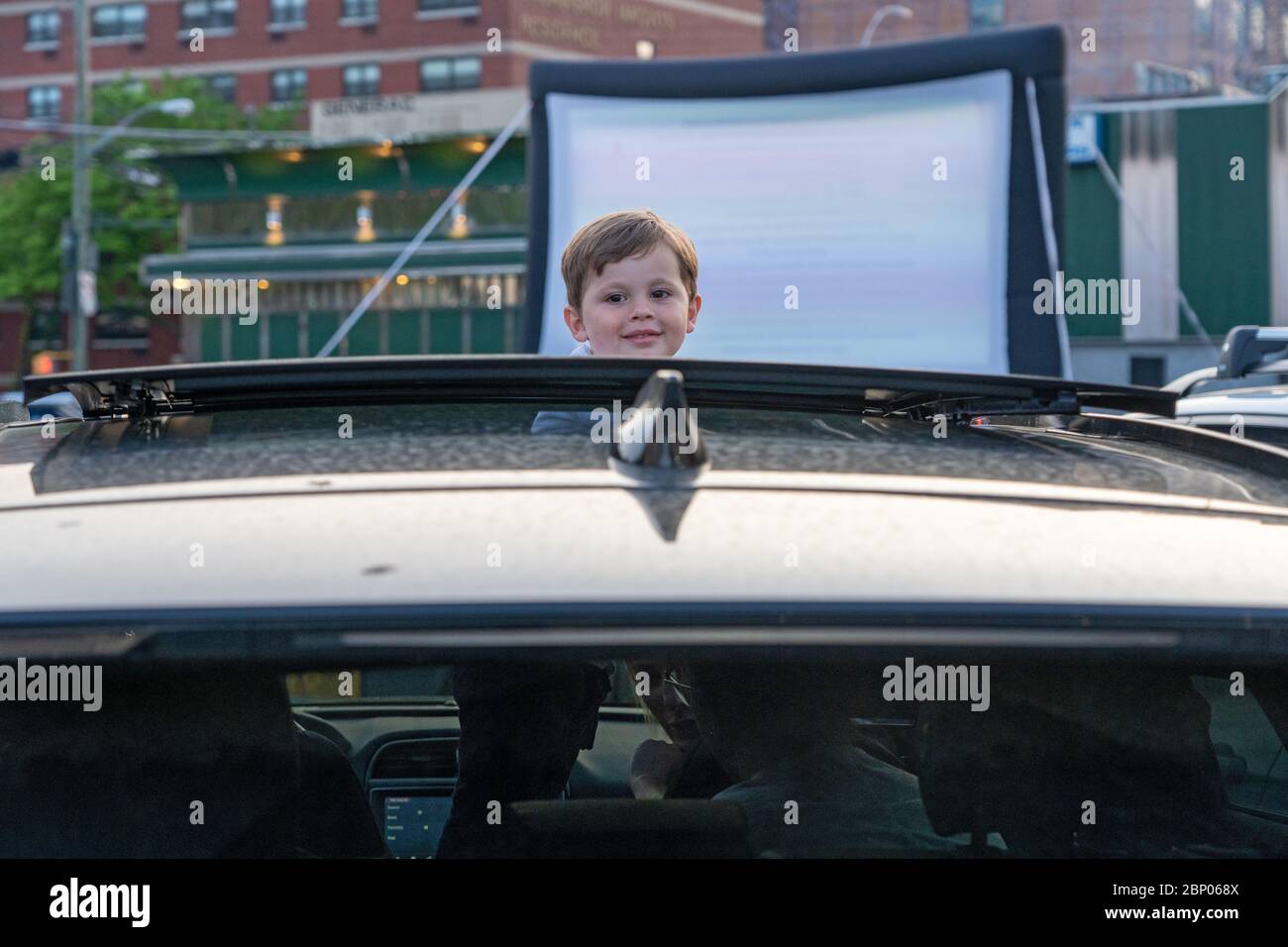 New York, Usa. Mai 2020. Ein Kind schaut durch ein Schiebedach während eines Pop-up Drive-in Films, der von Bel Aire Diner auf dem angrenzenden Parkplatz inmitten der Coronavirus (COVID-19) Pandemie in Queens Stadtteil New York City gezeigt wird. Quelle: SOPA Images Limited/Alamy Live News Stockfoto