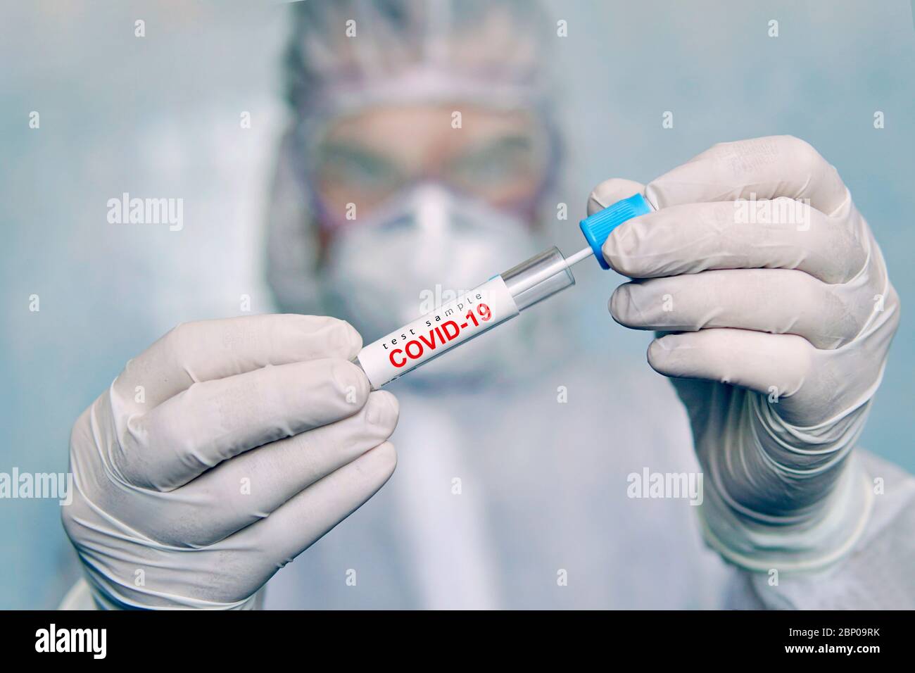 Ein Mann in einem chemischen Schutzanzug hält ein Reagenzglas für die Analyse. COVID-19. Coronavirus-Abstrichprobe COVID-19. Abstrichprobe Coronavirus-Test. Verwendeter Transport Stockfoto