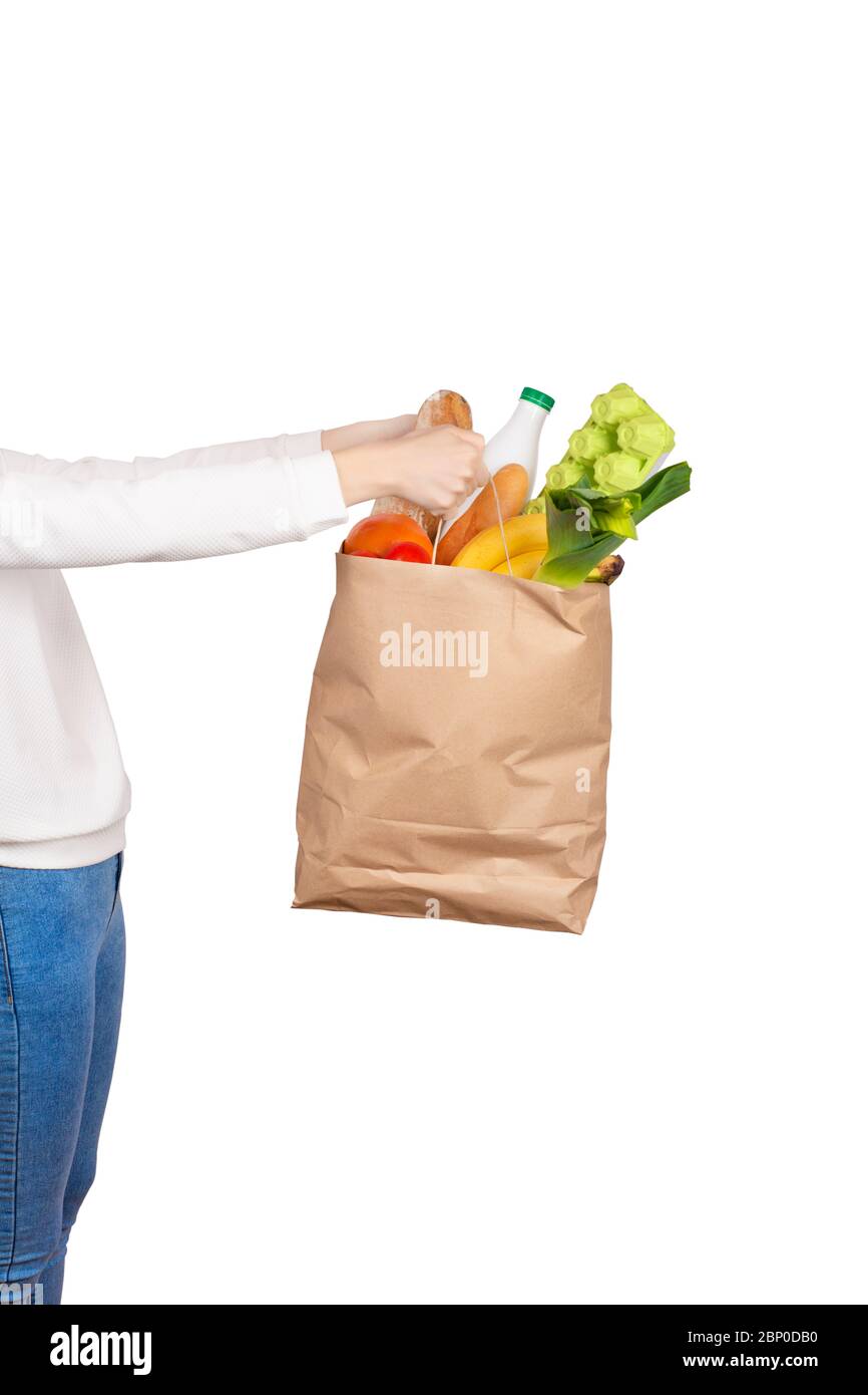 Food Delivery oder Spende Konzept. Lebensmittelgeschäft einkaufen. Mädchen hält eine Papiertüte mit Lebensmitteln wie Obst, Gemüse, Milch, Joghurt, Eier gefüllt Stockfoto