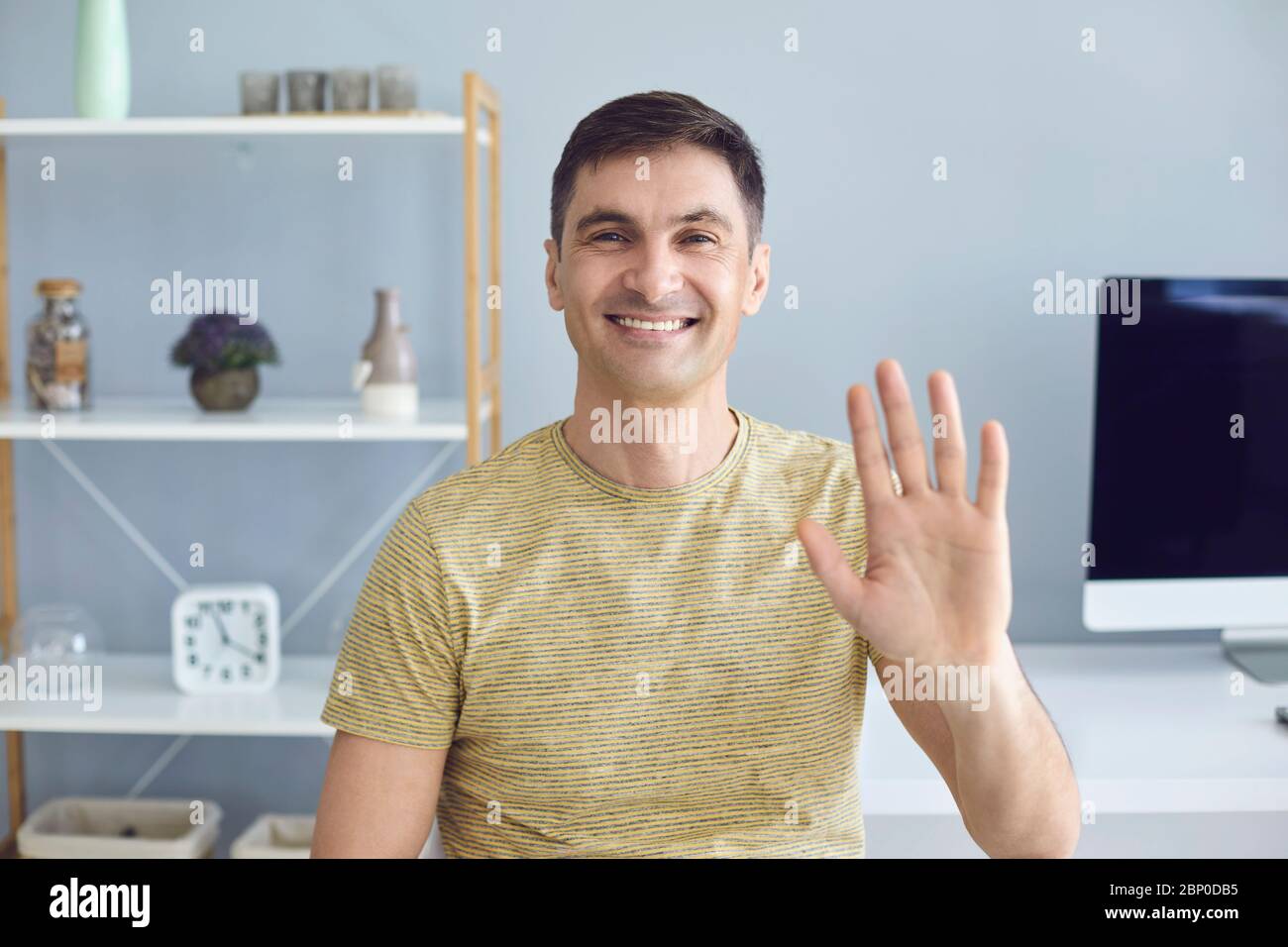 Geschäftsfrau in lässigem T-Shirt lächelnd, die Kamera zu Hause im Büro anblickend Stockfoto