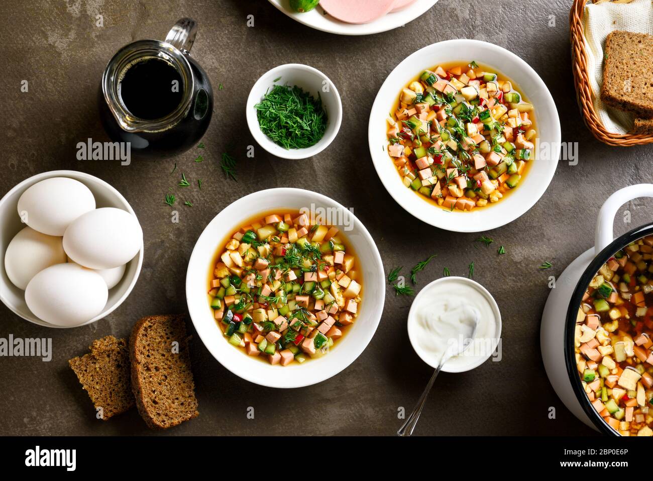 Sommer kalte russische Suppe Okroschka mit Wurst, Gemüse und Kvass auf braunem Hintergrund. Draufsicht, flaches Lay Stockfoto