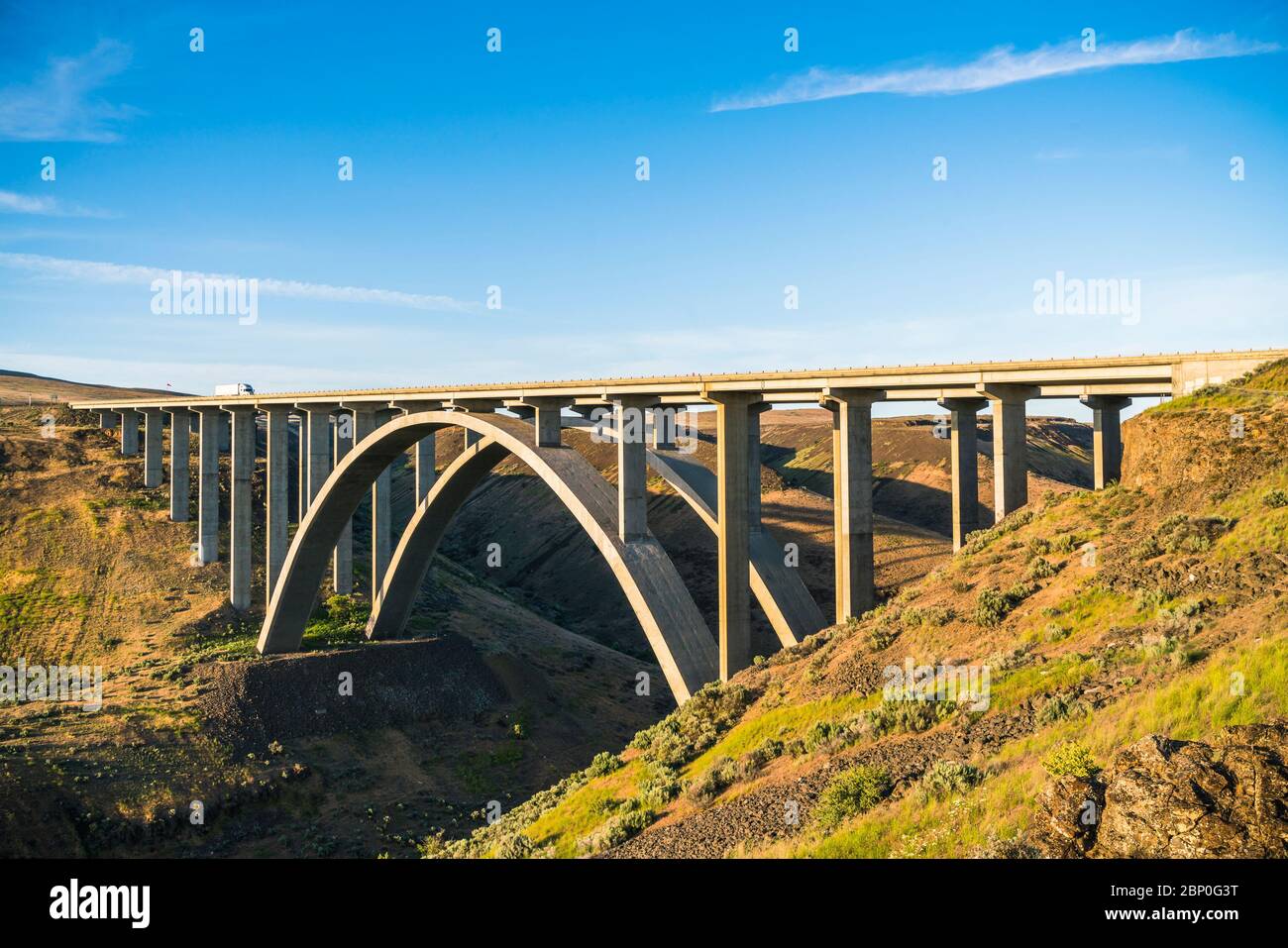 Bogen Betonbrücke ein überqueren den Fluss, wenn Sonnenuntergang. Stockfoto