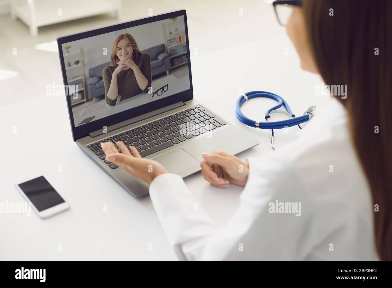 Arzt und Patient online. Ärztin mit Laptop Beratung Patienten Diagnose Video Chat Anruf Chat am Arbeitsplatz in der Klinik sitzen. Stockfoto