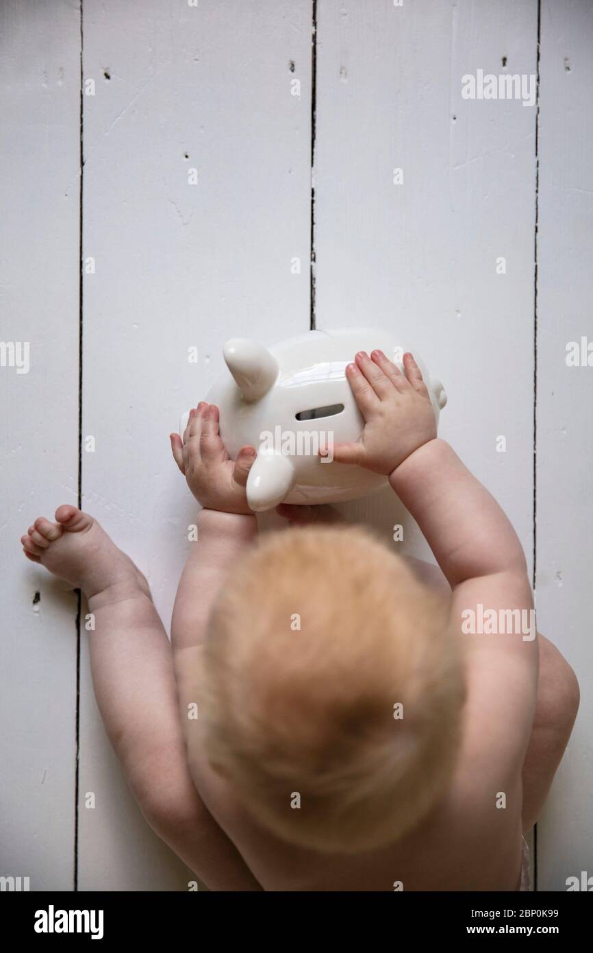 Overhead-Ansicht eines Babys mit einem Sparschwein für ihre Zukunft Stockfoto