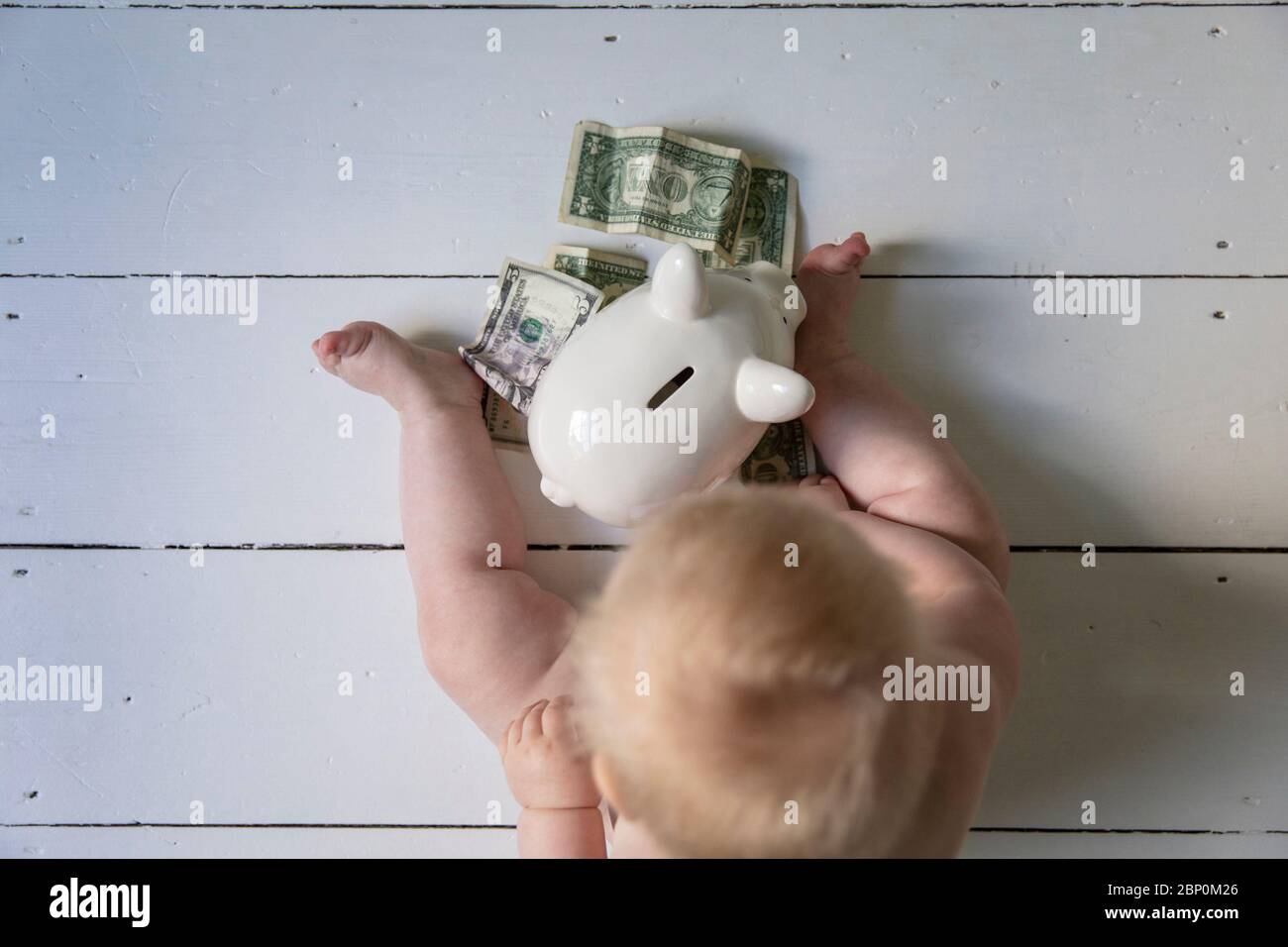 Sparen für die Zukunft. Nettes junges Baby mit einer Geldbox Stockfoto