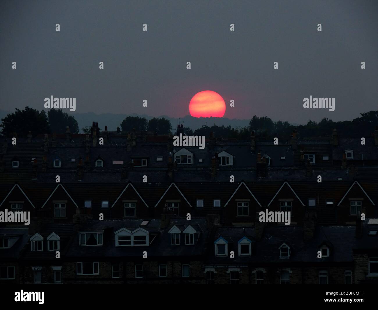 Ungewöhnliche Wetterfreaks mit einem großen roten Sonnenuntergang über der Stadt Whitby, Yorkshire England im Oktober 2015 Stockfoto
