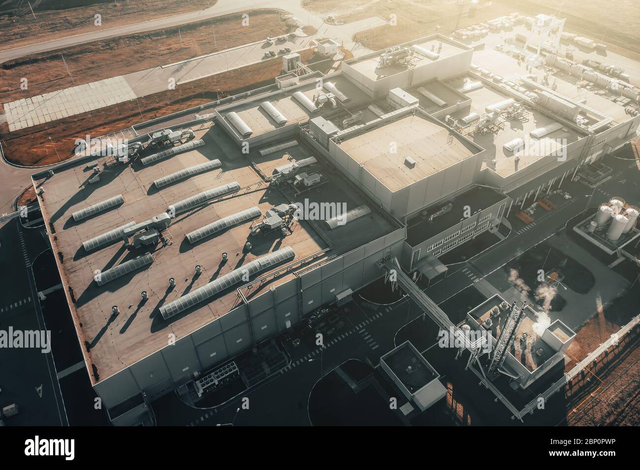 Luftaufnahme des großen Lagerhauses oder Fabrikgebäudes der industriellen Logistik bei Sonnenuntergang, Ansicht von oben. Stockfoto
