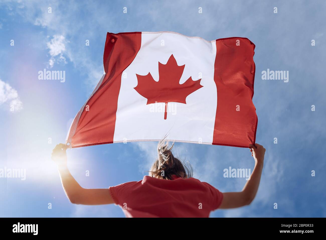 Kind Mädchen winkt kanadischen Flagge auf dem Gipfel des Berges am Himmel Hintergrund Stockfoto