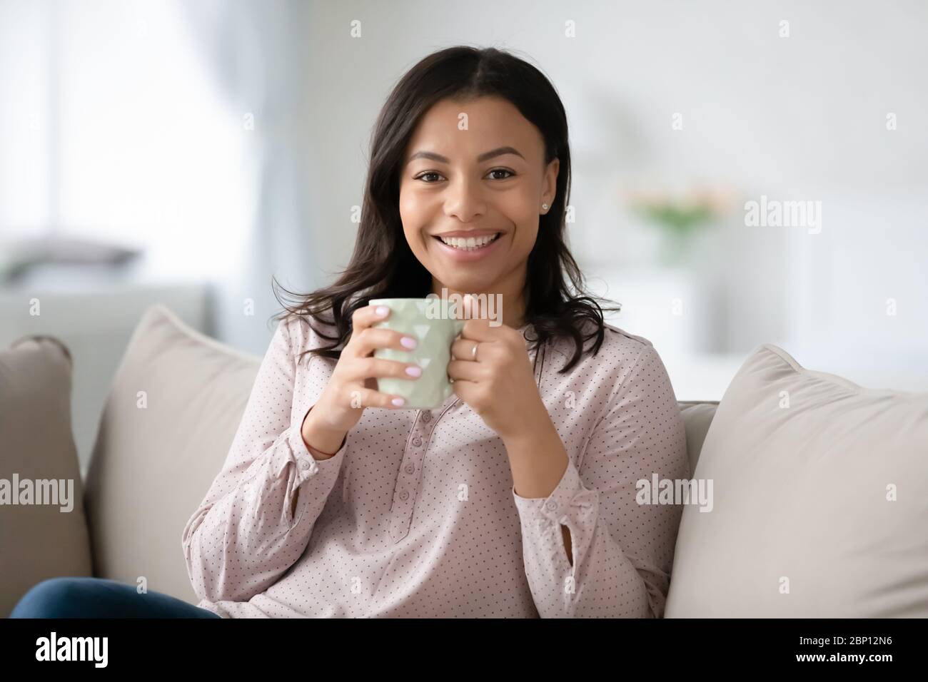 Afrikanische Frau hält Tasse Kaffee Pause zu Hause genießen Stockfoto