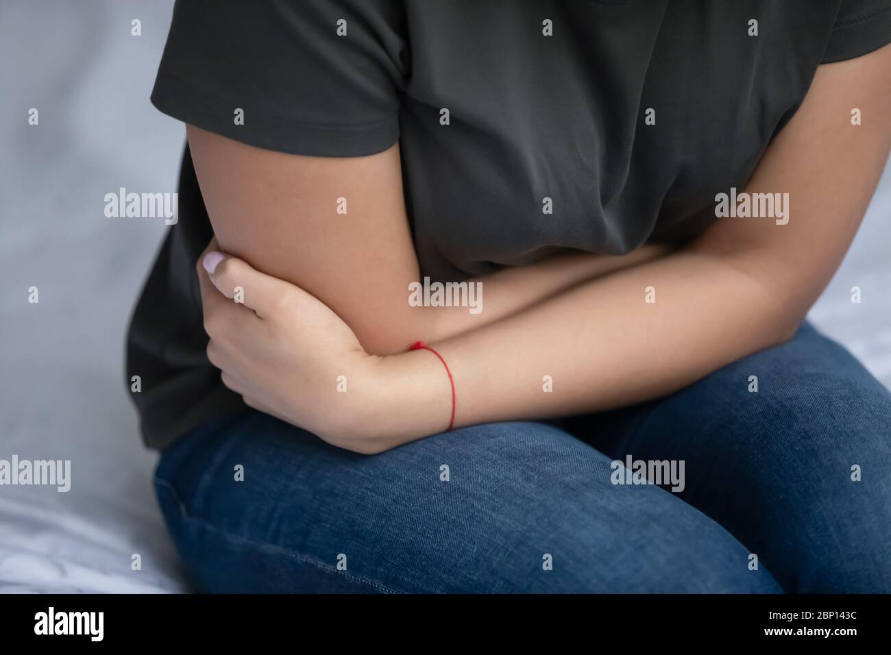 Nahaufnahme Bild Frau im Bett sitzen Gefühl Bauchschmerzen Stockfoto