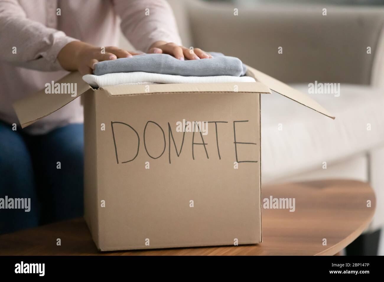 Frau vorbereitet Box mit alten Sachen für Spende Nahaufnahme Bild Stockfoto