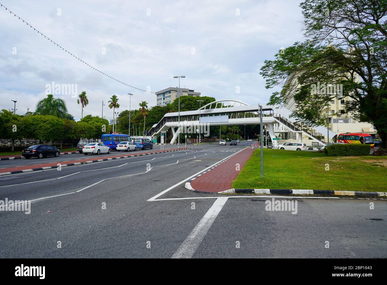 Straßenmarkierungen, Gehweg, Überführung und verschiedene Bäume von Bandar Seri Begawan, Brunei. November 2019 Stockfoto