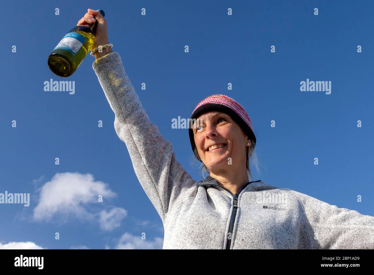 Frau feiert mit einer Flasche Wein Stockfoto