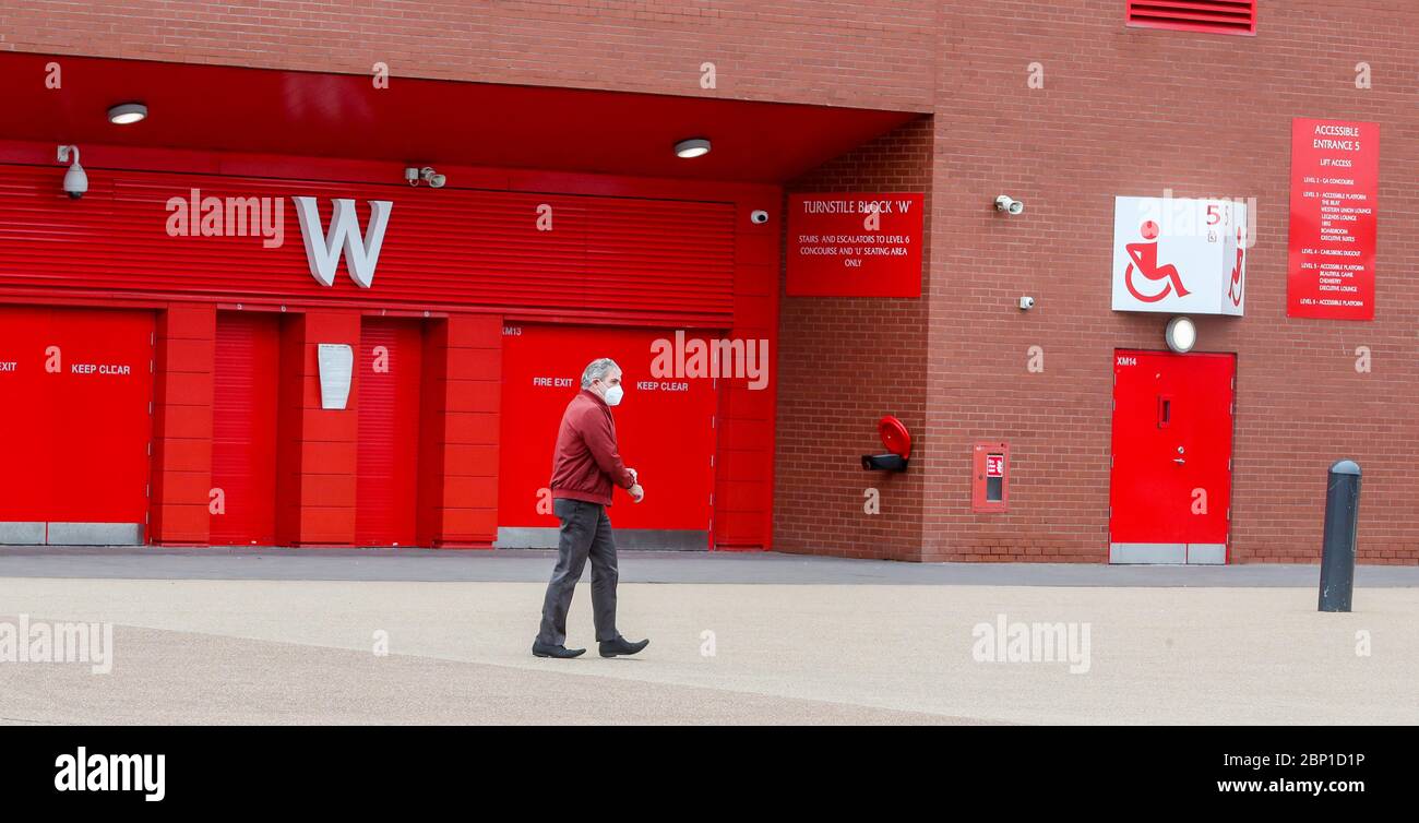 Ein Mann mit einer Gesichtsmaske (Abdeckung) geht vorbei an Anfield - Heimstadion der Premiership Tischkipper Liverpool. Heute hätte Liverpool ihr letztes Spiel der 19/20 Auswärtsspiel nach Newcastle im St James Park spielen sollen. Stockfoto