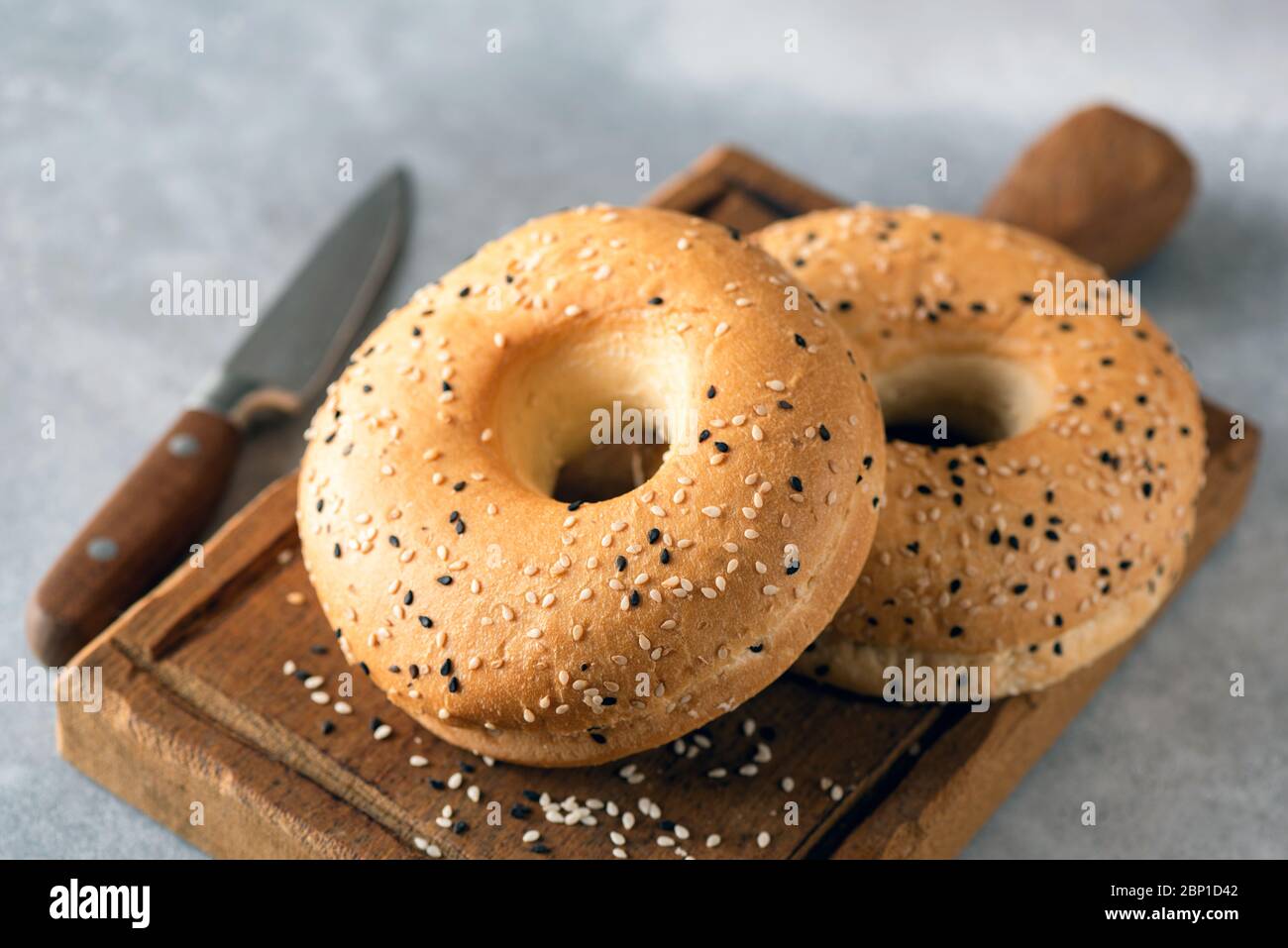 Sesamballe auf Holzbrett. Leckere frische zwei SesamBagels Stockfoto