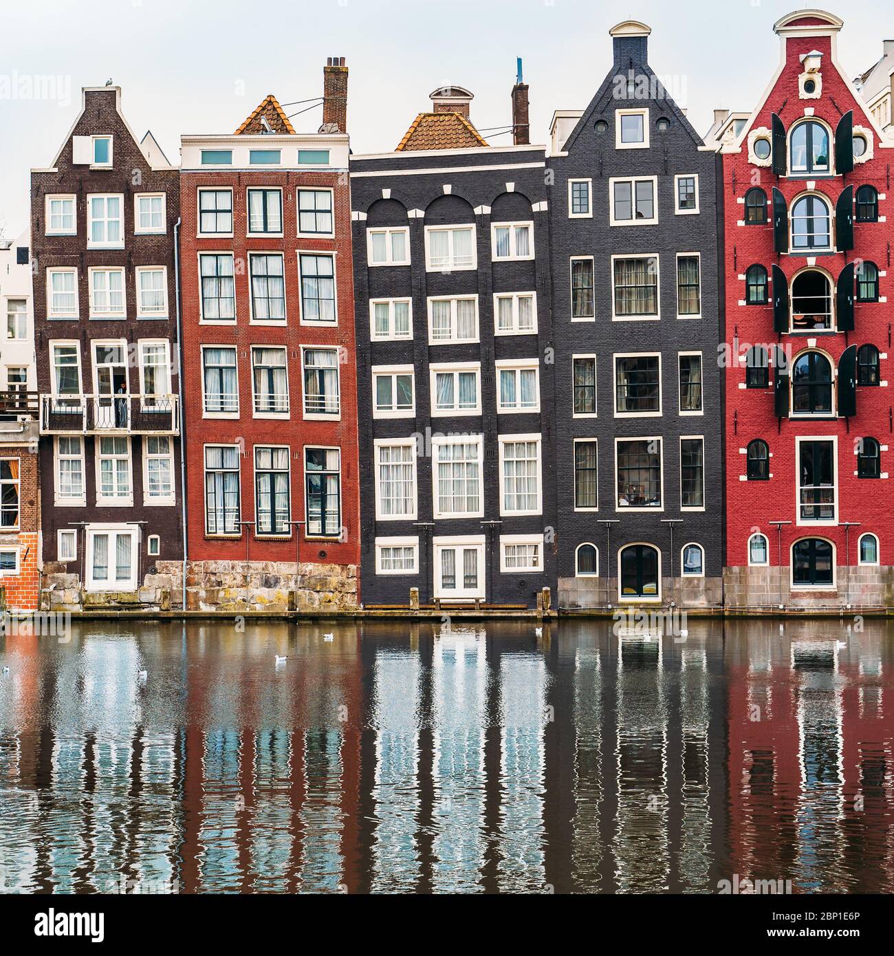 Berühmte Tanzhäuser und Gebäude in Amsterdam mit Spiegelung im Kanalwasser. Stockfoto