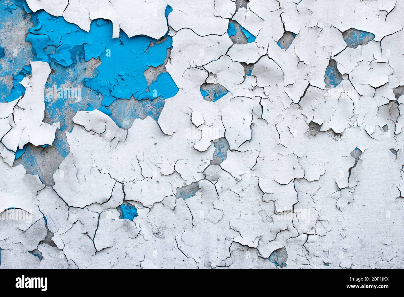 Abblätternde Farbe an einer Betonwand. Blau und weiß gemalt abstrakten Hintergrund, Grunge rissige Oberfläche, Muster Textur Stockfoto