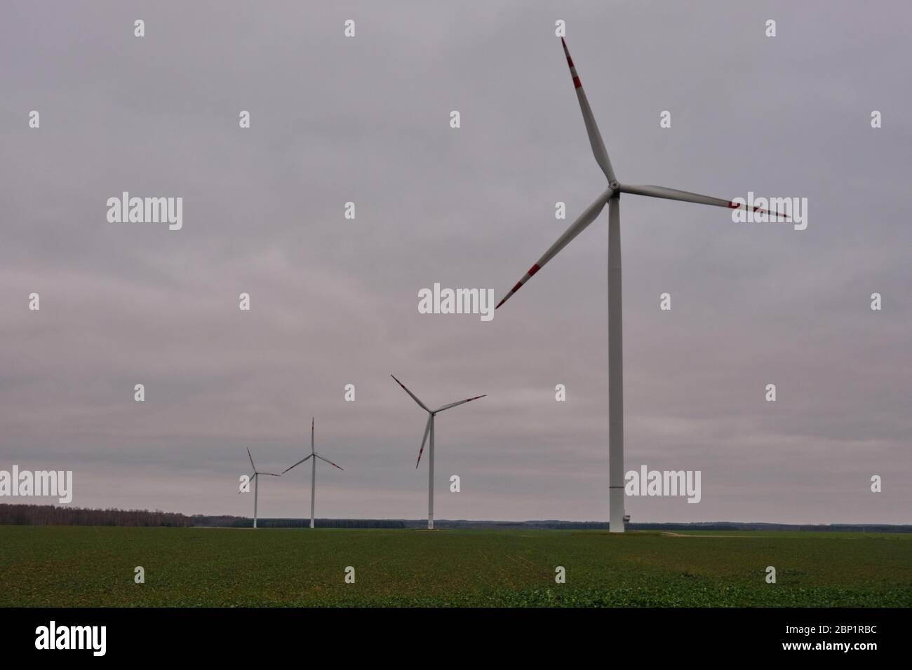 Windkraftanlage unter bewölktem Himmel über Feld, Woiwodschaft Podlaskie, Polen, Europa Stockfoto