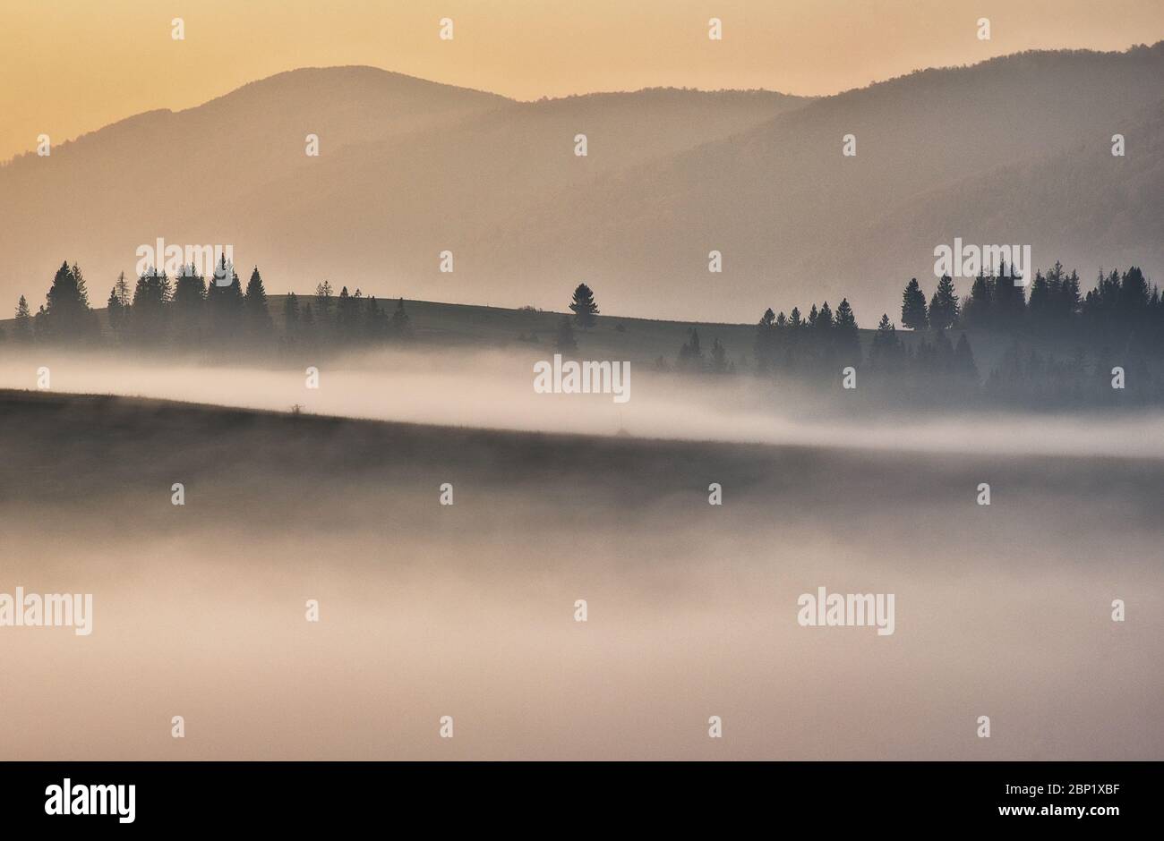 Vordämmerungszeit im Hochland. Bergsilhouetten im Nebel Stockfoto