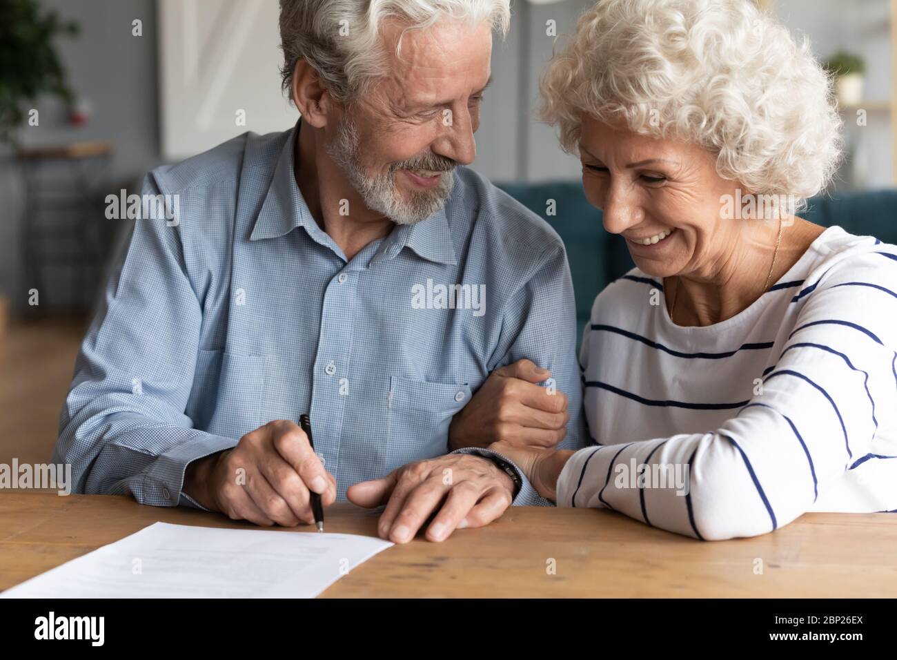 Lächelnd Mann Frau mittleren Alters, die Unterschrift auf Ehepartner. Stockfoto