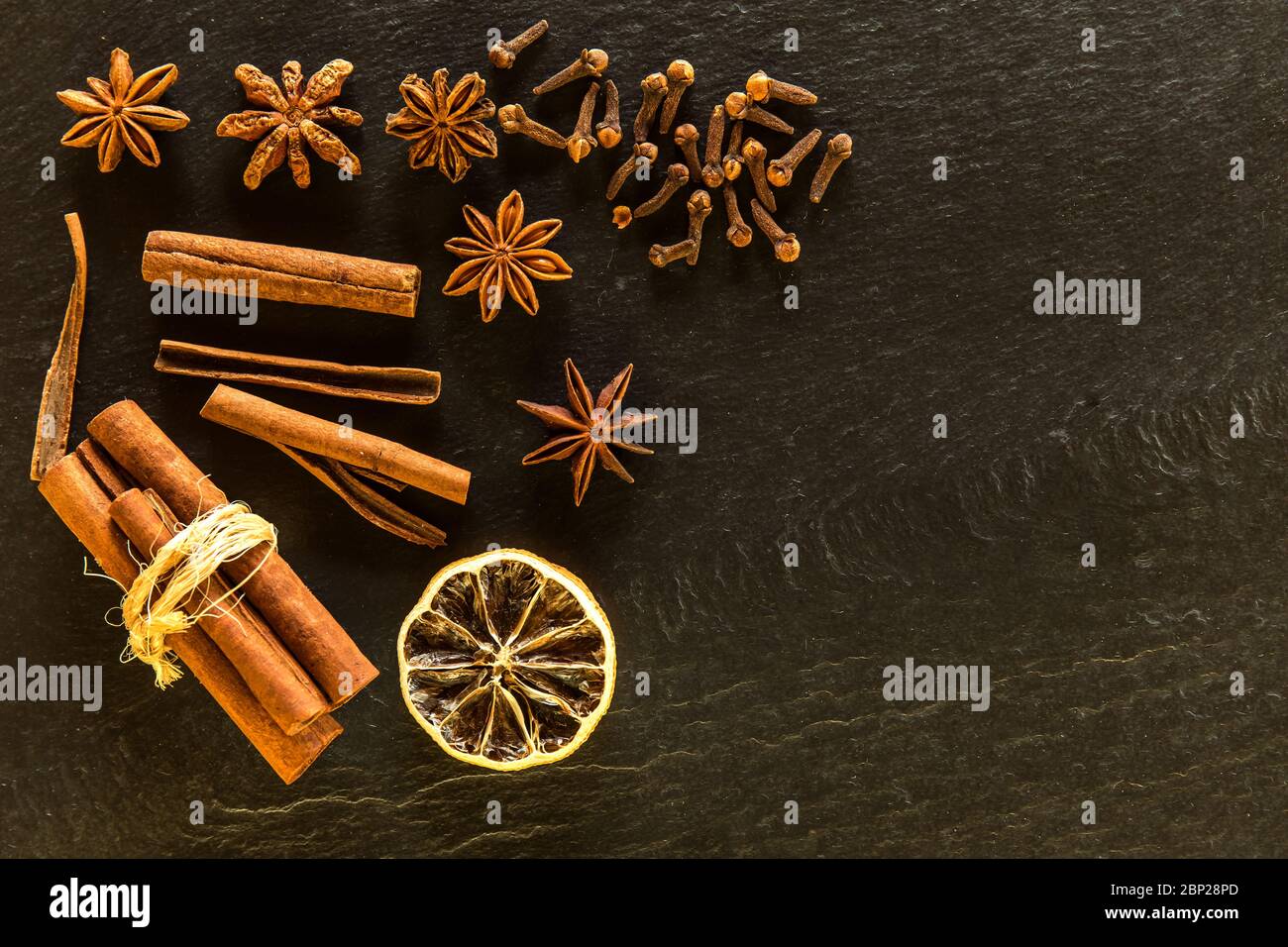 Traditionelle Weihnachtsgewürze - Sternanis mit Zimt und Nelken auf Schiefer. Aromatische Gewürze. Stockfoto