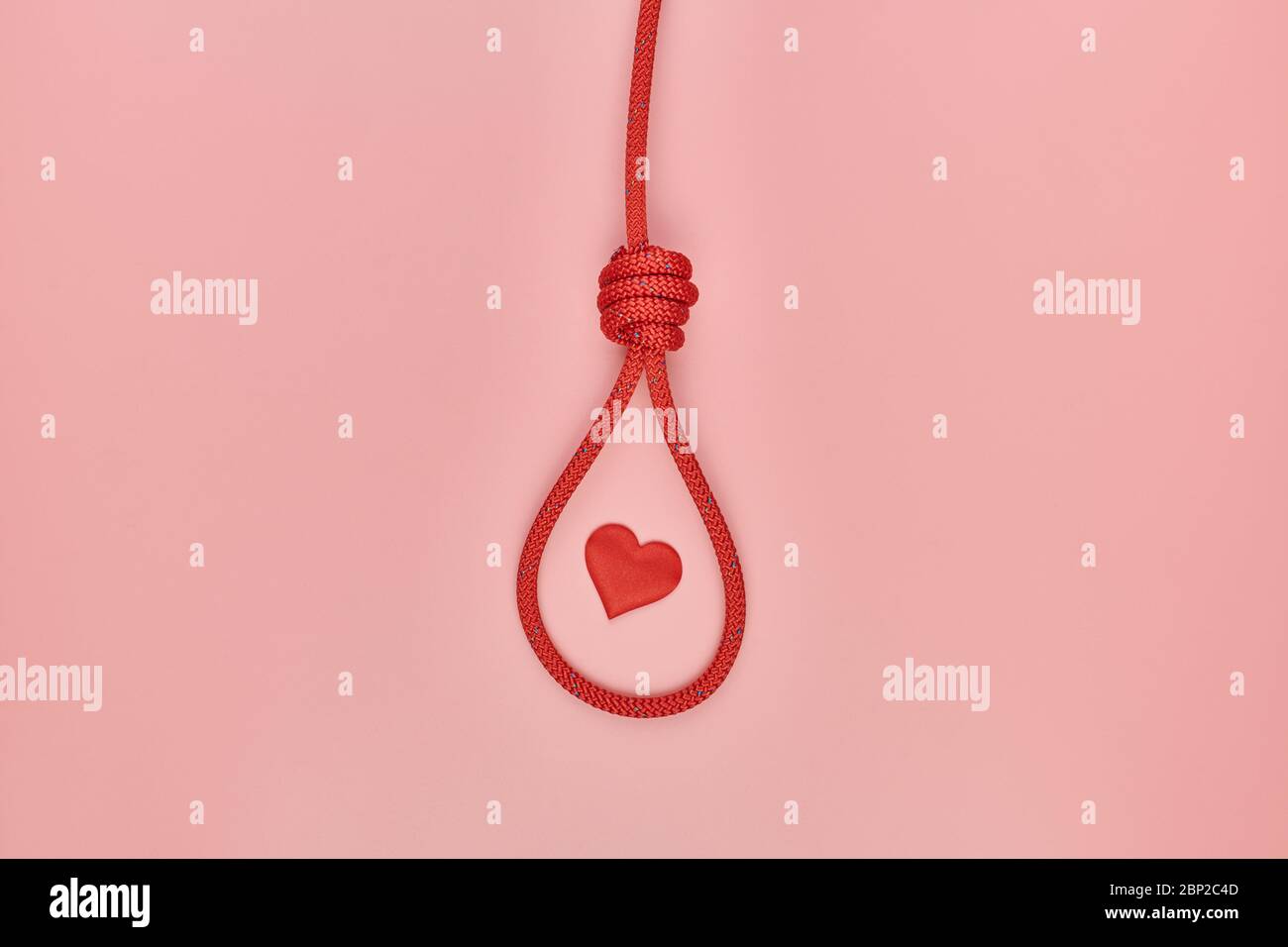 Herz im Knoten des Henkers. Unerhörte Liebe hängenden Selbstmord Konzept. Rote geflochtene Hängeschlinge Band den Knoten. Symbol für Valentinstag fehlgeschlagen Stockfoto