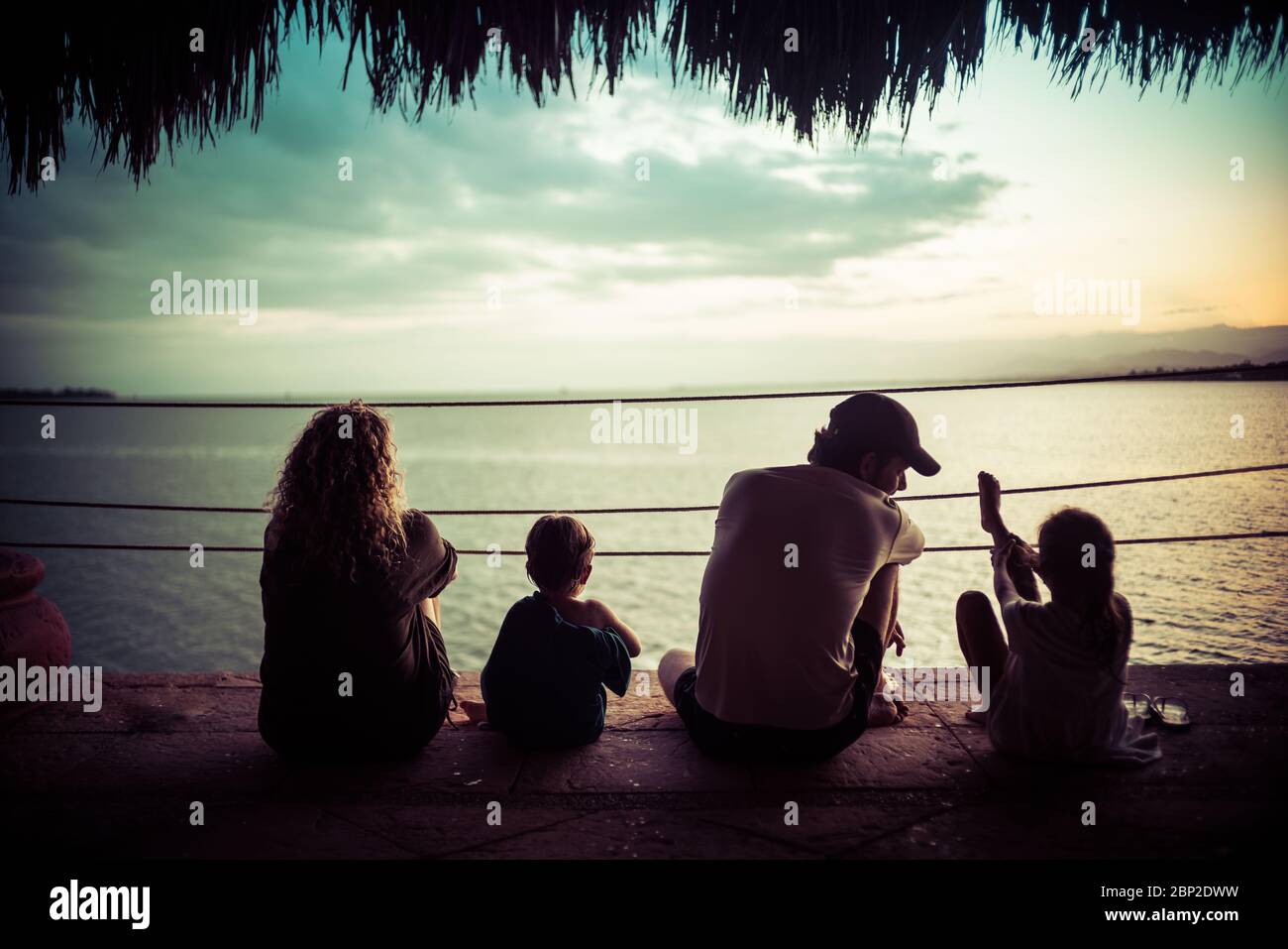 Familie im Urlaub, die einen Sonnenuntergang beobachtet. Stockfoto