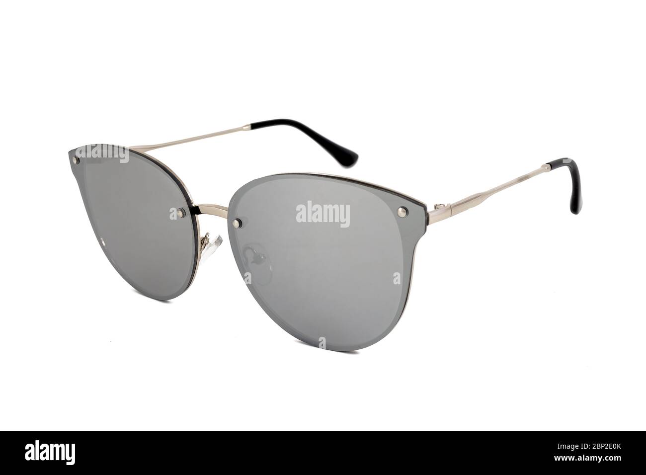 Silberne randlose ovale Sonnenbrille mit Katzenaugen und Spiegelgläsern auf weißem Hintergrund, Seitenansicht. Stockfoto