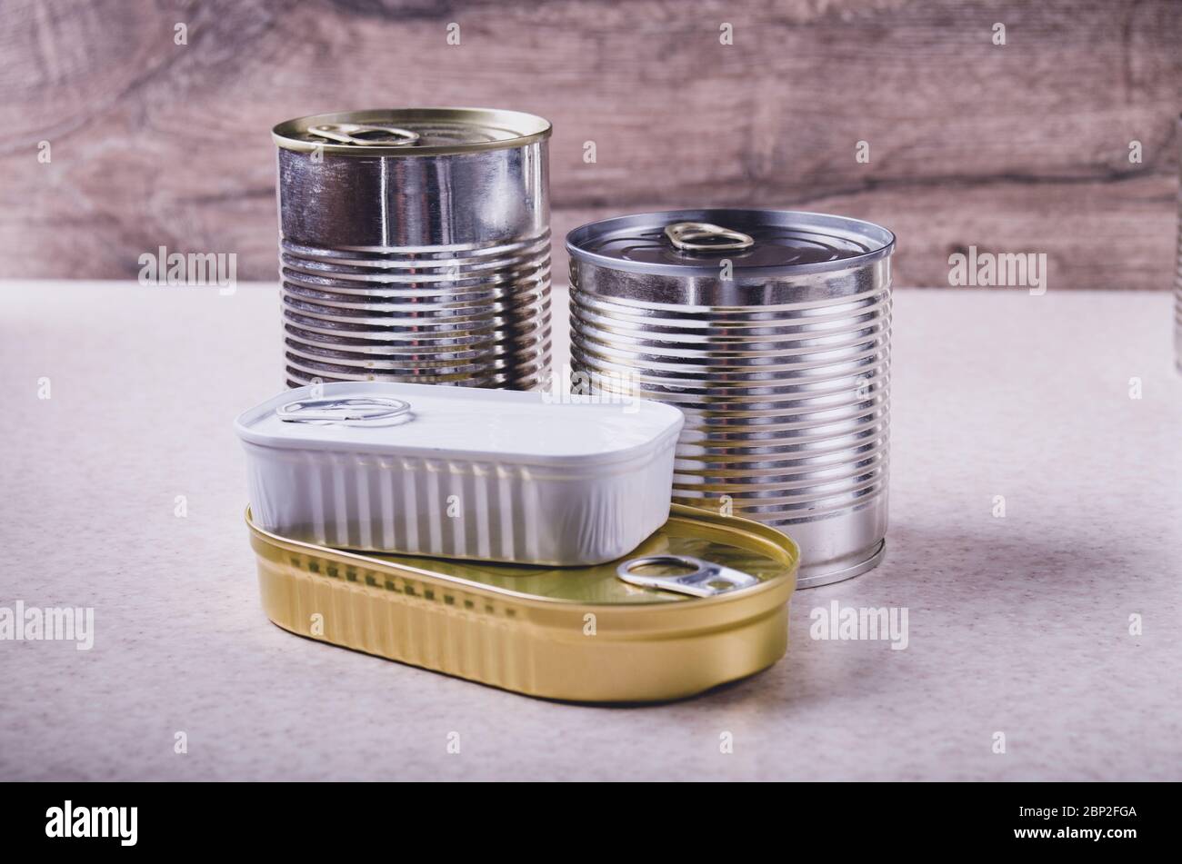 Set von verschiedenen Konserven in Dosen auf Küchentisch, nicht verderbliche, lange Haltbarkeit Lebensmittel für das Überleben in Notsituationen Konzept Stockfoto