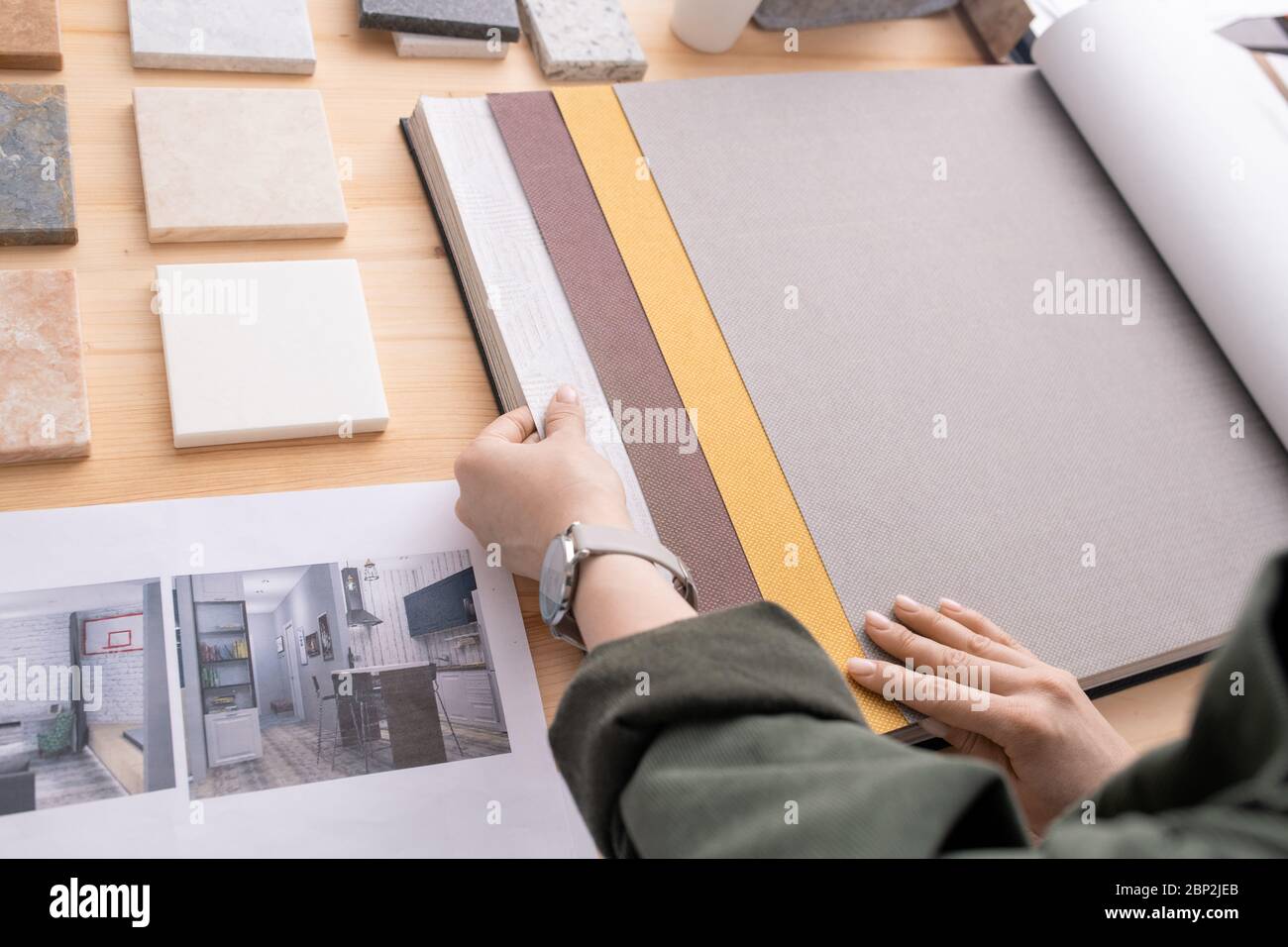 Hände von jungen zeitgenössischen Designer suchen durch Proben von Tapeten für Wände des Zimmers des neuen Hauses oder Wohnung Stockfoto