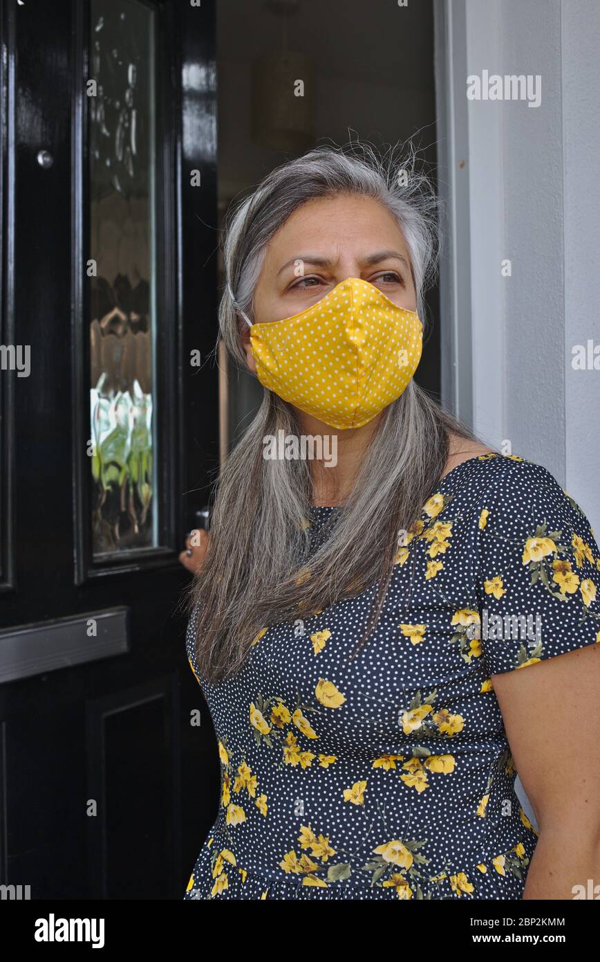 Die Neue Normalität. Frau mit Gesichtsmaske, um während der Coronavirus Covid-19-Pandemie das Haus zu verlassen. England, Großbritannien. Mai 2020 Stockfoto
