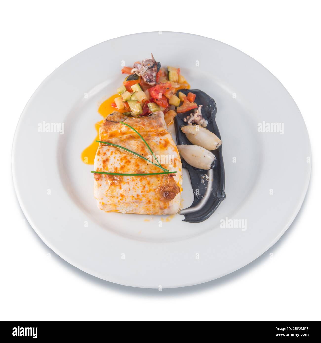 Platte gebackener Seehecht mit Tintenfisch in der Tinte und Schnittlauch. Stockfoto