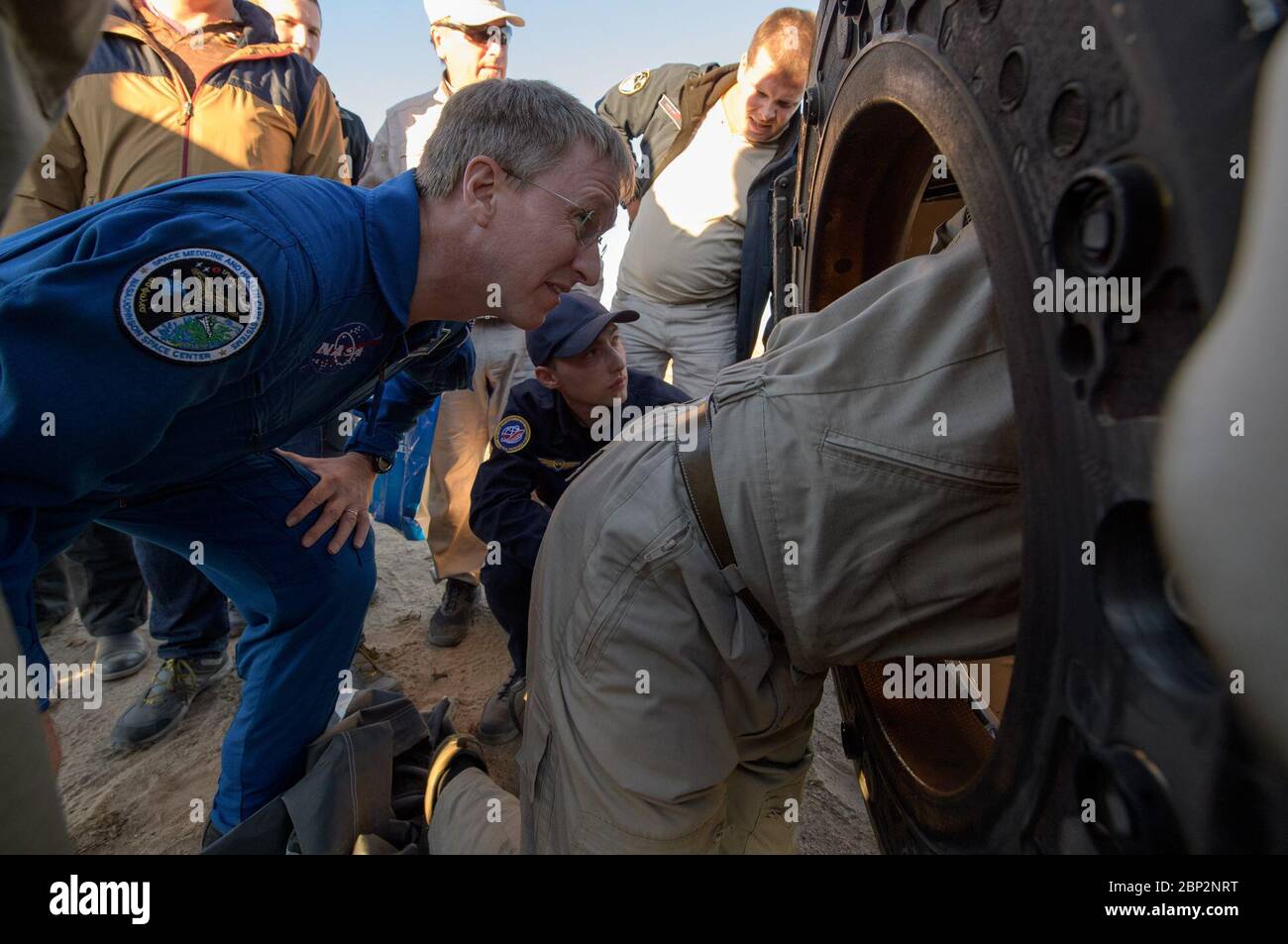 Expedition 56 Sojus MS-08 Landung NASA Flugchirurg Joe Schmid, links, schaut in die Sojus MS-08 Raumsonde, um die Expedition 56 zu überwachen Kommandant Drew Feustel und Flugingenieur Ricky Arnold von der NASA, zusammen mit Flugingenieur und Sojus Commander Oleg Artemyev von Roskosmos in der Nähe der Stadt Zhezkazgan, Kasachstan am Donnerstag, Oktober 2018. Feustel, Arnold und Artemijew kehren nach 197 Tagen im All zurück, wo sie als Mitglieder der Expedition 55 und 56 Besatzungen an Bord der Internationalen Raumstation dienten. Stockfoto