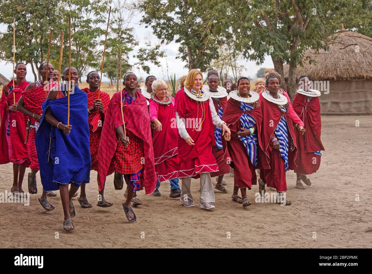 Maasai Dorf; indigene Bevölkerung; traditionelle Kleidung, Besucher, Männer, Frauen, Gehen, Lernen, Bildung, Kultur teilen, am meisten lächelnd, Tansania; AFR Stockfoto