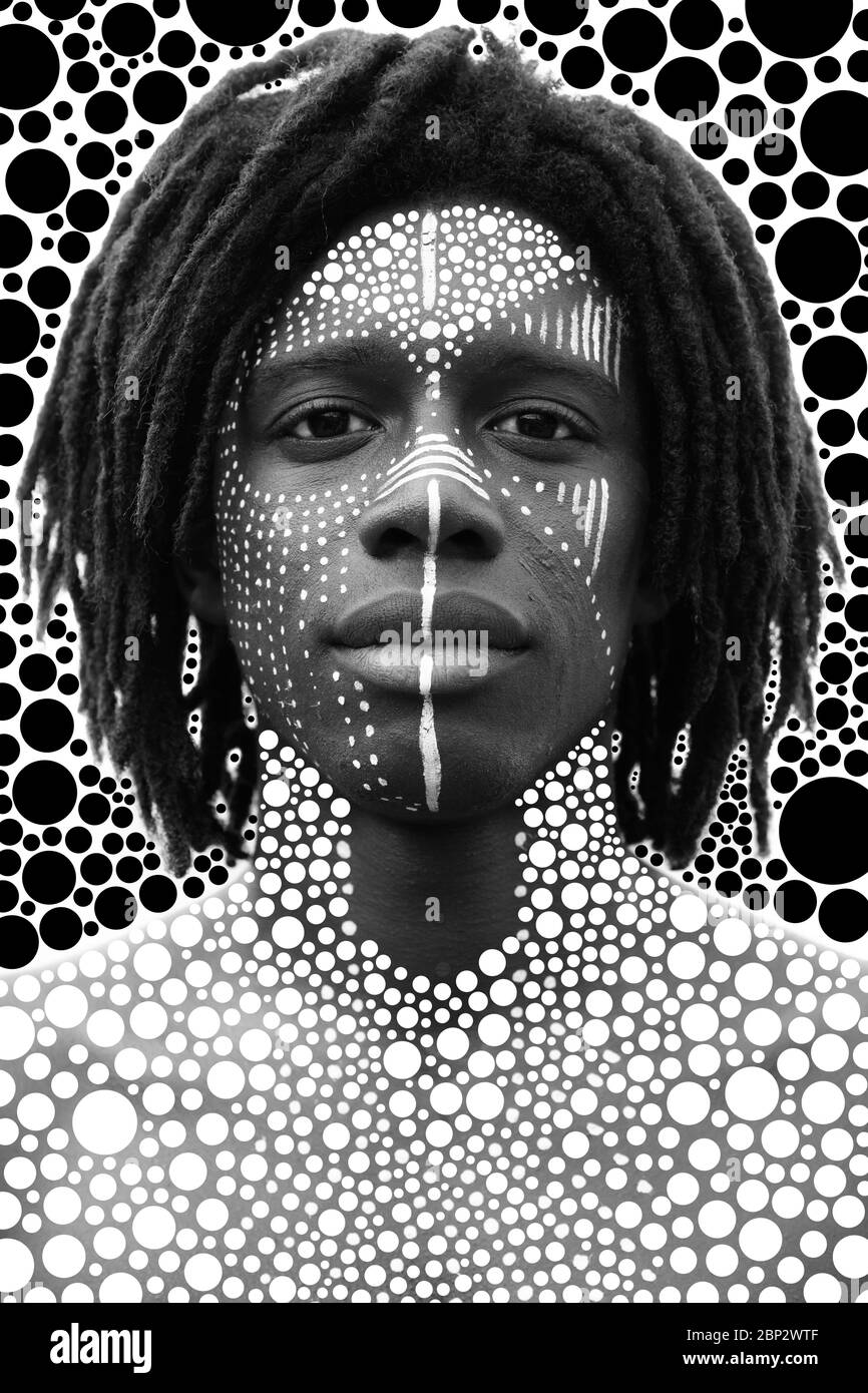 Porträt eines jungen afrikaners mit Dreadlocks und traditioneller Gesichtsfarbe, die direkt in die Kamera schauen Stockfoto