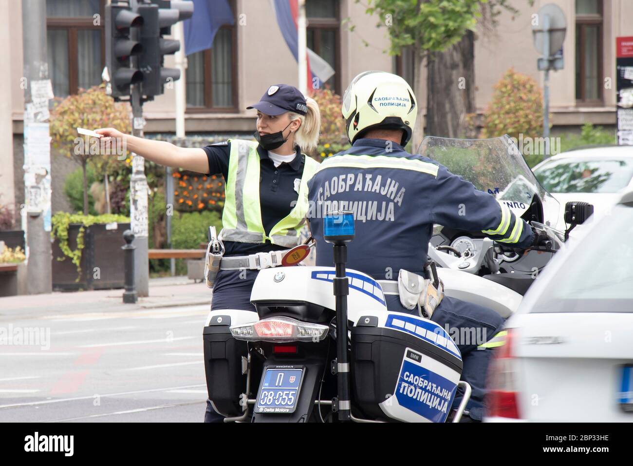 Belgrad, Serbien - 15. Mai 2020: Verkehrspolizistin und Motorpolizist im Dienst, stehend an der Kreuzung und sprechend Stockfoto