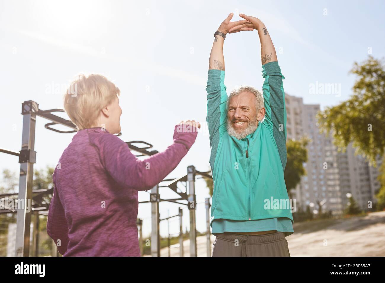 Gesunde Lebensweise. Schöne ältere oder ältere Familie Paar in Sportbekleidung tun Dehnungsübungen zusammen am frühen Morgen im Outdoor-Fitnessstudio Stockfoto