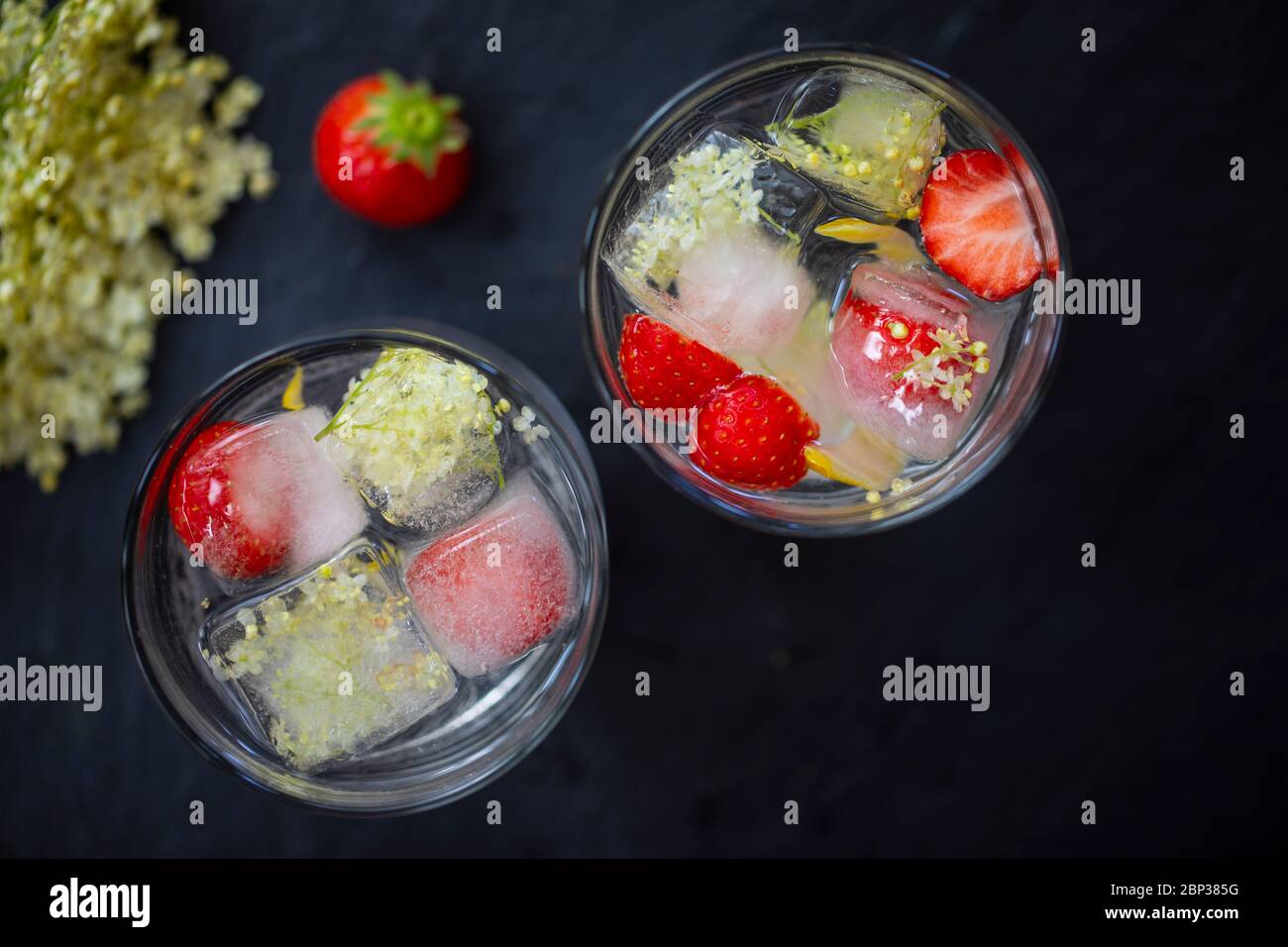 Gin Tonic mit Eldehußwürfeln und strawbery garnieren Stockfoto