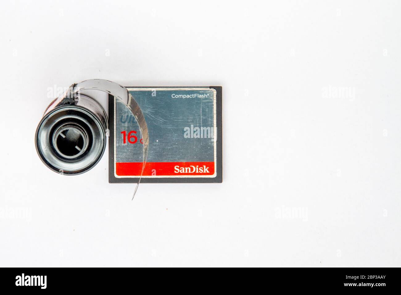 Overhead-Aufnahme einer 35-mm-Filmkassette neben einer 16-GB-sd-Karte vor einem weißen Hintergrund mit Platz zum Kopieren Stockfoto